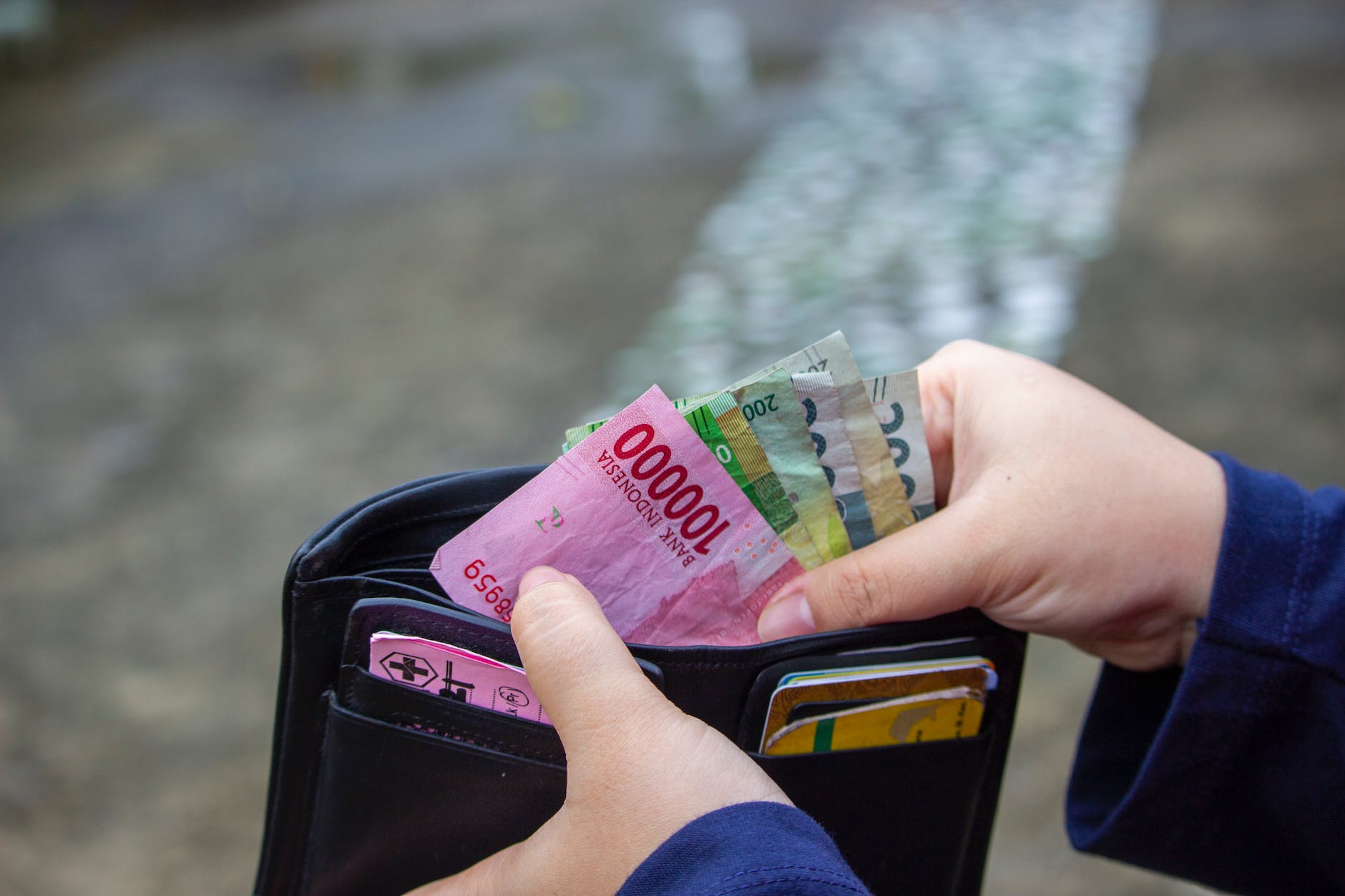 a person getting money on a wallet